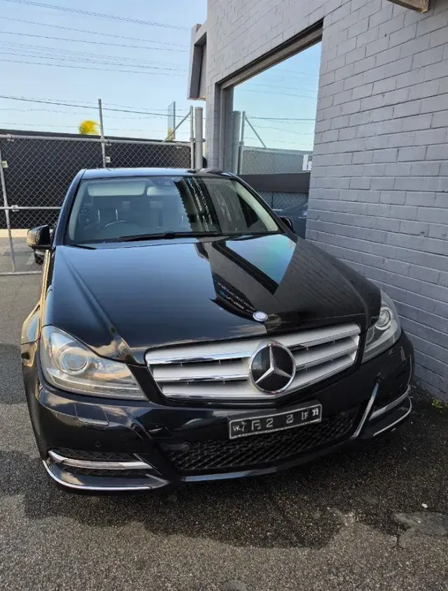 Black Mercedes-Benz C-Class parked on a driveway before a mobile service