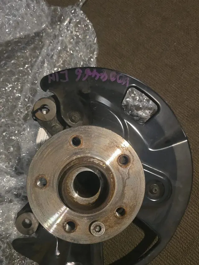 Rear wheel hub and backing plate removed from a car for a bearing replacement